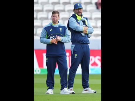 Australia’s Steve Smith (left) and bowling coach Daniel Vettori watch players warm up before the start of play on day four of the World Test Championship final between South Africa and Australia at Lord’s cricket ground in London on Saturday.