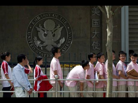 Chinese students wait outside the U.S. Embassy for their visa application interviews, in Beijing on May 2, 2012. 