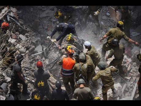 FILE - Israeli soldiers search for survivors amid the rubble of residential buildings destroyed by an Iranian missile strike in Bat Yam, central Israel, June 15.