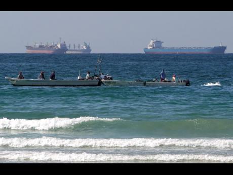 In this January 19, 2012 photo, fishing boats are seen in front of oil tankers south of the Strait of Hormuz.