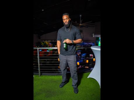 Credit: Contributed Cinematographer and fitness trainer Oj Black, dressed in a sleek black T-shirt and jeans, poses with a cold Heineken in hand.