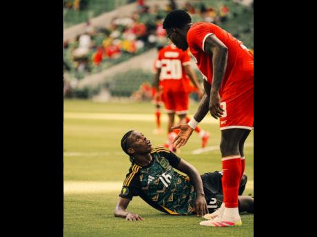 Credit: Courtesy of JFF Media Panama’s José Córdoba offers a hand to Jamaica’s Warner Brown after fouling him during a Concacaf Gold Cup encounter at the Q2 Stadium on Tuesday.