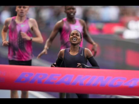 Faith Kipyegon, from Kenya, approaches the finish line in her attempt to become the first woman to run a mile in under four minutes, at Stade Charlety in Paris, Thursday, June 26, 2025. (AP Photo/Christophe Ena)