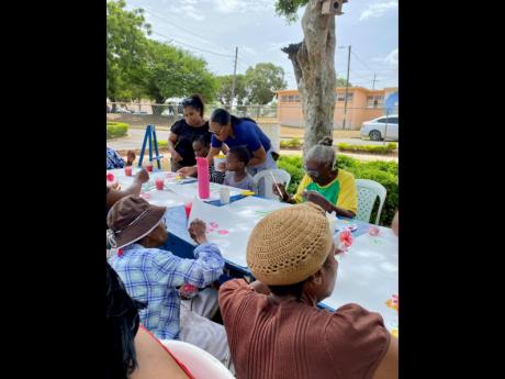 Asheaka James, trade marketing manager at Berger Paints; and Barbara Rodriguez, occupational therapist at Bellevue Hospital, assist with distributing paint and overseeing the paint-and-sip activity at the Family Day event.