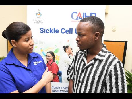 Tabra-Kay Lindsay, sales relations specialist at JN Bank Small Business Loans, in discussion with Richard Ffrench, operator of Ivory Ja, a clothing brand, during the Sickle Cell Transformative and Empowerment Programme organised by the Sickle Cell Unit and