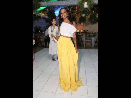Shawntelle Housen, manager of Locale, showcases the boutique’s breezy elegance in a one-shoulder white crop top paired with a flowing lemon-yellow maxi skirt.