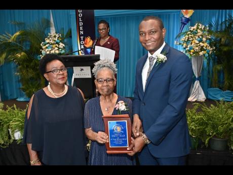 Credit: Rudolph Brown It’s a special moment for the Isaacs family as veteran educator and honouree Dorothy Isaacs (centre) is presented with a special award by Dr Mark Smith, president of the Jamaica Teachers’ Association, while her daughter Sharon (left) looks on.