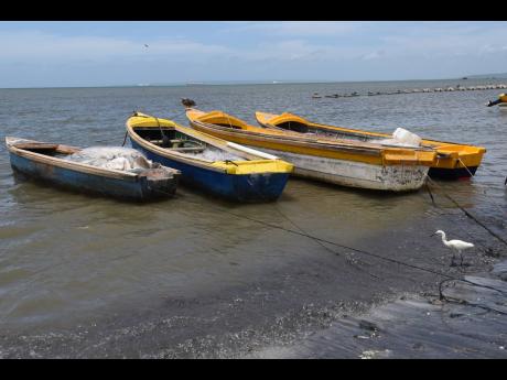 Boats line the shores of the Old Harbour fishing village on July 13, 2021, as heavy winds prevented fishermen from venturing out to sea. A local weather app is among the safety tools now available for fishers to prepare adequately before venturing out to s