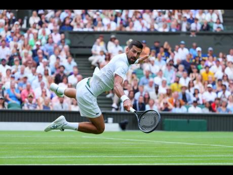 
Novak Djokovic of Serbia dives to return to Miomir Kecmanovic of Serbia during a third round men’s singles match at the Wimbledon Tennis Championships in London yesterday.