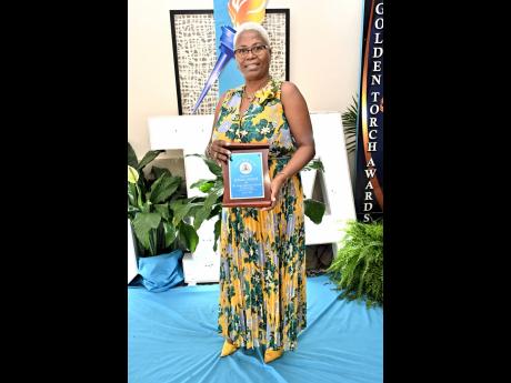 Educator Barbara Hurlock brings a burst of sunshine to the room as she collects her plaque, honouring 36 years of dedicated service to education.