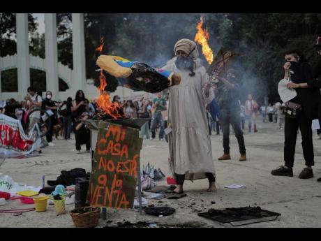 
A demonstrator burns an effigy of US President Donald Trump in Parque Mexico, during a protest against gentrification, as the increase in remote workers has boosted prices and increased housing demand in neighbourhoods like Condesa and Roma, in Mexico Cit