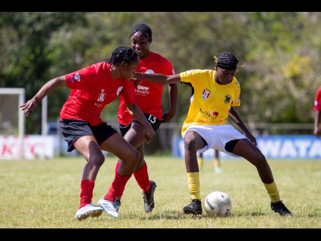 Frazsiers Whip’s Cassandra Smith (right) keeps the ball away from a pair of Mile Gully players during a Jamaica Women’s Premier League encounter at Brook Park in Mandeville.