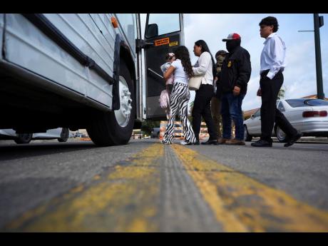 A family from Colombia is detained and escorted to a bus by federal agents following an appearance at immigration court Monday, July 14, 2025, in San Antonio. (AP Photo/Eric Gay)