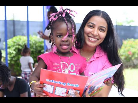Brittany Roberts (right), brand manager for the Wata portfolio, Wisynco Group, shares a cheerful moment with little Emily Lindsey during the Reggae Sumfest Family Fun Day, held on July 13 at Catherine Hall Stadium in Montego Bay. CranWATA was one of the ev