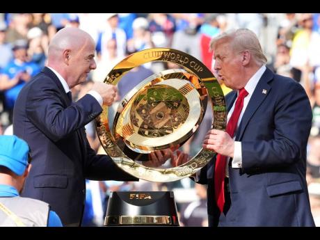 President Donald Trump (right) and FIFA President Gianni Infantino carry the championship trophy at the conclusion of the Club World Cup final football match at MetLife Stadium in East Rutherford, New Jersey, on Sunday.