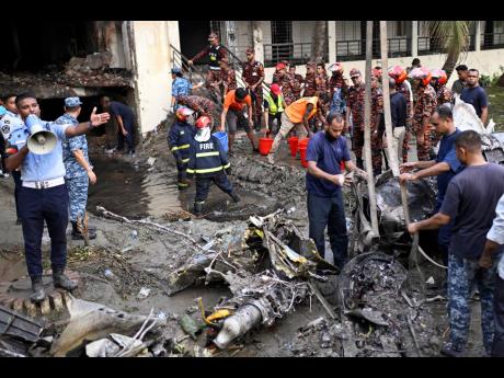 Credit: AP Mahmud Hossain Opu Firemen work at the site of a Bangladesh Air Force training aircraft that crashed into a school campus shortly after takeoff in Dhaka, Bangladesh, yesterday.