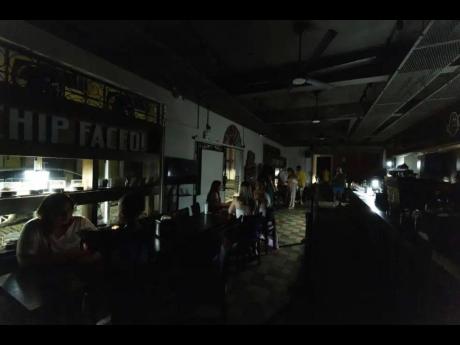 Customers sit inside a restaurant lit by battery-powered lanterns during an island-wide power outage, in Old San Juan, Puerto Rico, April 16, 2025.