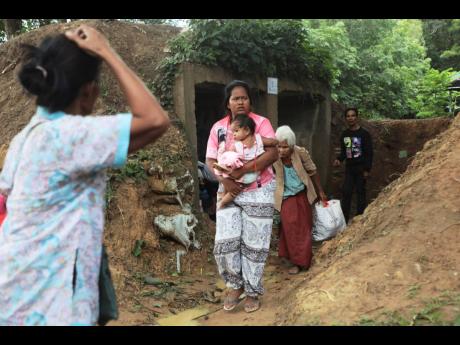 Thai people who fled clashes between Thai and Cambodian soldiers take shelter in Surin province, northeastern Thailand, yesterday.