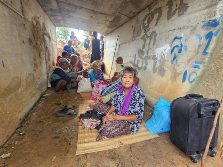Thai people who fled clashes between Thai and Cambodian soldiers take shelter in Surin province, northeastern Thailand, yesterday.
