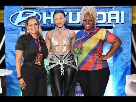Luz Tejada, managing director, Magna Motors; Anna-Lisa Guthrie; and Carla Hollingsworth, marketing manager at Hyundai Jamaica, strike a pose at Reggae Sumfest Festival Night One, following Guthrie’s bold Hyundai-inspired fashion reveal.