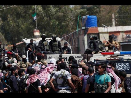 Syrian government security forces block Bedouin fighters (foreground) from entering Sweida province, in Busra al-Harir village, southern Syria.