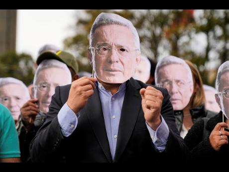 Supporters of former Colombian President Alvaro Uribe hold cutouts of his face outside the court in Bogota, Colombia on Monday.