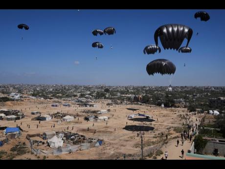 
Palestinians rush to collect humanitarian aid airdropped into Zawaida in central Gaza Strip last Thursday.