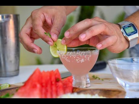 Credit: Matthew McKoy Wynton Hudson garnishes the summer thyme, a watermelon and thyme margarita, with a slice of lime.