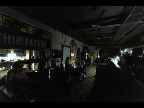 Customers sit inside a restaurant lit by battery-powered lanterns during an islandwide power outage, in Old San Juan, Puerto Rico, April 16, 2025. 