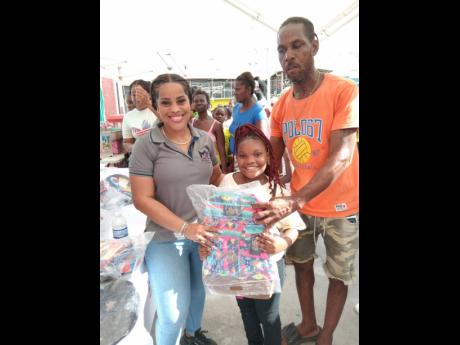 M&M’s Chief Executive Officer, Marcel Williams makes a presentation to a parent and child.