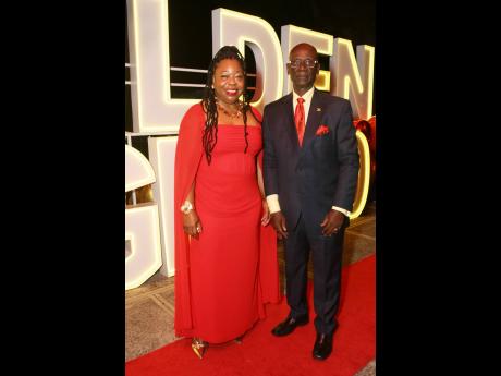 General manager of the Golden Age Home, Zonia Foster-Forbes, captures the moment with Local Government Minister Desmond McKenzie.