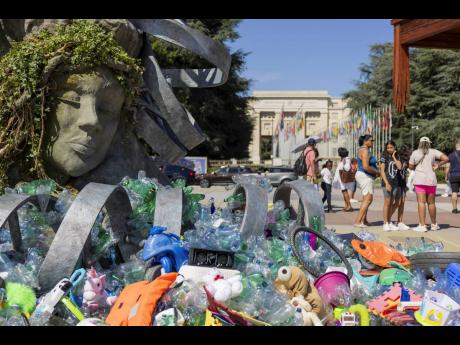Credit: AP
Plastic items are seen next to an artwork by Canadian artist and activist Benjamin Von Wong, titled ‘The Thinker’s Burden’, a six-metre-tall sculptural remix of Rodin’s iconic ‘Thinker’, created especially for the plastics treaty negotiations,