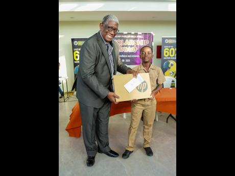 Chairman of Marathon Insurance Brokers, Richard Burgher, presents the award to top male performer, Shaundee Goldson of Rollington Town Primary School, during the Annual Scholarship Programme Awards Ceremony which was held on  Wednesday, August 13 at the P