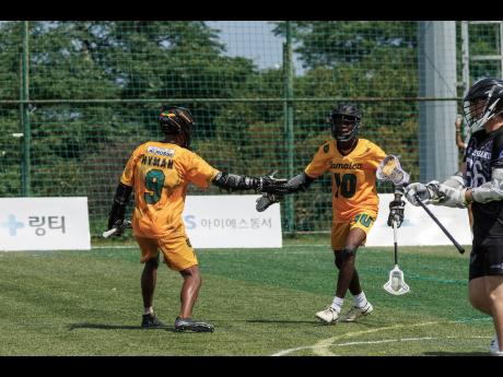 Jamaica’s Carl Hyman (left) and Sanjay Tomlinson (right) celebrate scoring a point against New Zealand at the World Lacrosse Men’s U20 Championships on Tuesday.