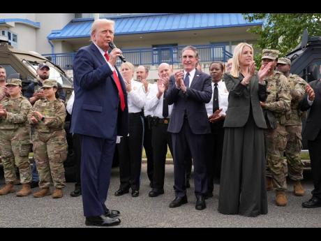 President Donald Trump speaks with members of law enforcement and National Guard soldiers, Thursday, August 21, in Washington, as Interior Secretary Doug Burgum and Attorney General Pam Bondi listen. 