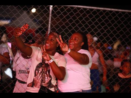 Patrons Natoya Campbell (right) and her niece Amoy snapping photos throughout Chris Martin’s set, one of their highlights of the day.