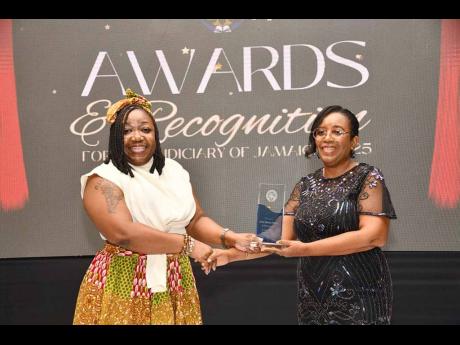 Kimya Beedle Fisher (left), St James Parish Court assistant clerk of court, collecting the People’s Choice Everyday Hero Award from Ann-Marie Cummings, principal financial officer, Court Administration Division.