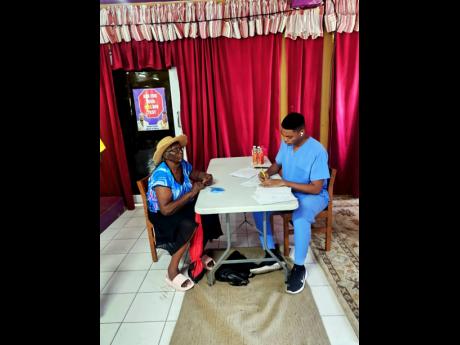 Dr Eric Dixon attending to a patient at the health and back-to-school fair.