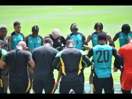 Jamacia’s Reggae Boyz get into a huddle during a practice session at the National Stadium.