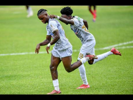 Denzel McKenzie (left) of Cavalier Soccer Club celebrates his second goal of the match with teammate Shaquille Stein during the Jamaica Premier League (JPL) football match against Arnett Gardens Football Club at Sabina Park in Kingston on Monday.