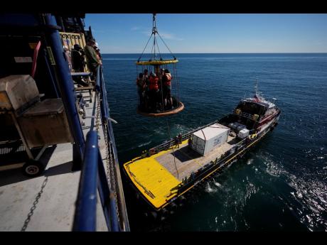 
Expedition 501 members in a Billy Pugh basket are lowered from the Liftboat Robert platform to the Gaspee, a crew transport vessel, in the North Atlantic, Saturday, July 19, 2025.
