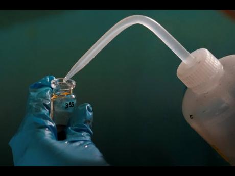 Expedition 501 researcher Jack Brickell prepares a sample vial for analysis aboard the Liftboat Robert platform in the North Atlanti.