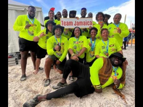 Corporal Oshane Wilson  (front) and Constable Rushaine Tyrell (first left, back row) join fellow Jamaican team members showing off bronze medals won in the 200-metre Mixed Major Final at the fourth Bahamas International Chinese Dragon Boat Festival in Nass