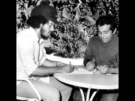 Allan ‘Skill’ Cole (left) signing a contract to play for the Brazilian Club Nautico, with the club’s envoy and team doctor Omar DiSilva at the Flamingo Hotel in Kingston in 1972.