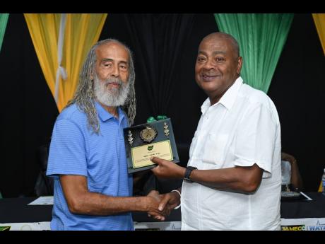 Michael Ricketts (right), president of the Jamaica Football Federation presents an award to Allan ‘Skill’ Cole at a ceremony at the federation’s head office on St Lucia Avenue in 2024.