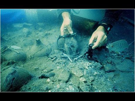 Credit: Artefacts, including a pewter tankard, smoking pipes, and onion wine bottles uncovered underwater during the Jamaica National Heritage Trust divers’ exploration of the Port Royal Heritage Site.