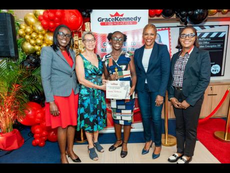 Credit: Grade 10 student at Immaculate Conception High School, Ameliya McPherson (centre), accepts her Carlton Alexander Memorial Bursary from Professor Julie Meeks-Gardner, chair of the GraceKennedy Foundation, during the awards ceremony held on August 29. Sharin