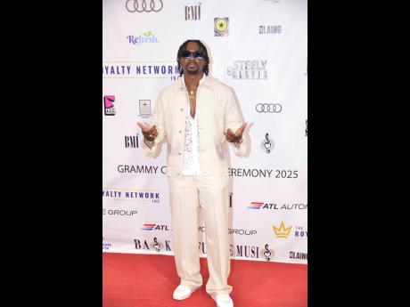 Christopher Martin hits the red carpet in an all-white ensemble, featuring a cream jacket and pants paired with a white shirt and matching shoes.