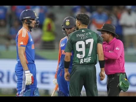 The umpire (right) mediates between Indian players Abhishek Sharma (left) and Shubman Gill and Pakistan’s Haris Rauf (second right) during the Asia Cup cricket match between India and Pakistan in Dubai yesterday.
