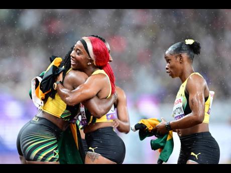Jamaica’s Jonielle Smith (left) hugs Shelly-Ann Fraser-Pryce while Tina Clayton looks on after the three, along with Tia Clayton, mined silver in the women’s 4x100-metre relay on Sunday’s final day of the World Athletics Championships in Tokyo, Japan
